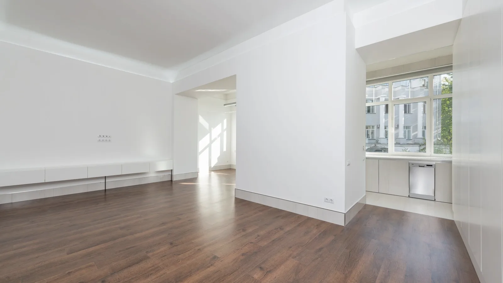 An empty apartment with bare floors and bright windows on moving day
